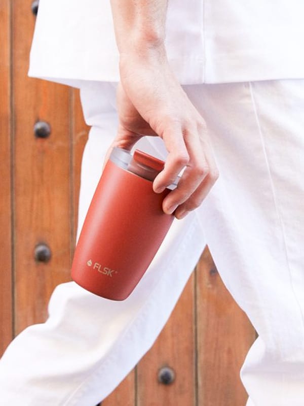 Individualisierter roter Kaffeebecher in der Hand – perfektes Werbemittel für unterwegs mit starkem Branding-Effekt